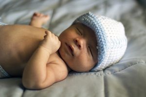 Baby turns one year old, sleeping peacefully on bed.