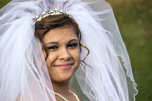 Bride smiles in her wedding dress before ceremony.