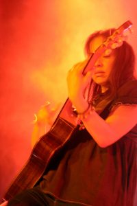 Gabriela gets lost in the guitar on stage of Rodrigo y Gabriela.